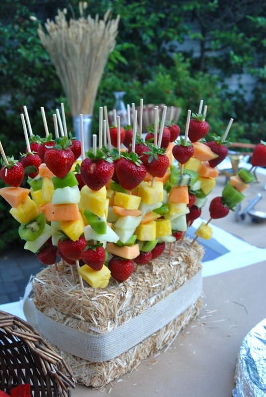 fruit skewers are arranged on top of straw