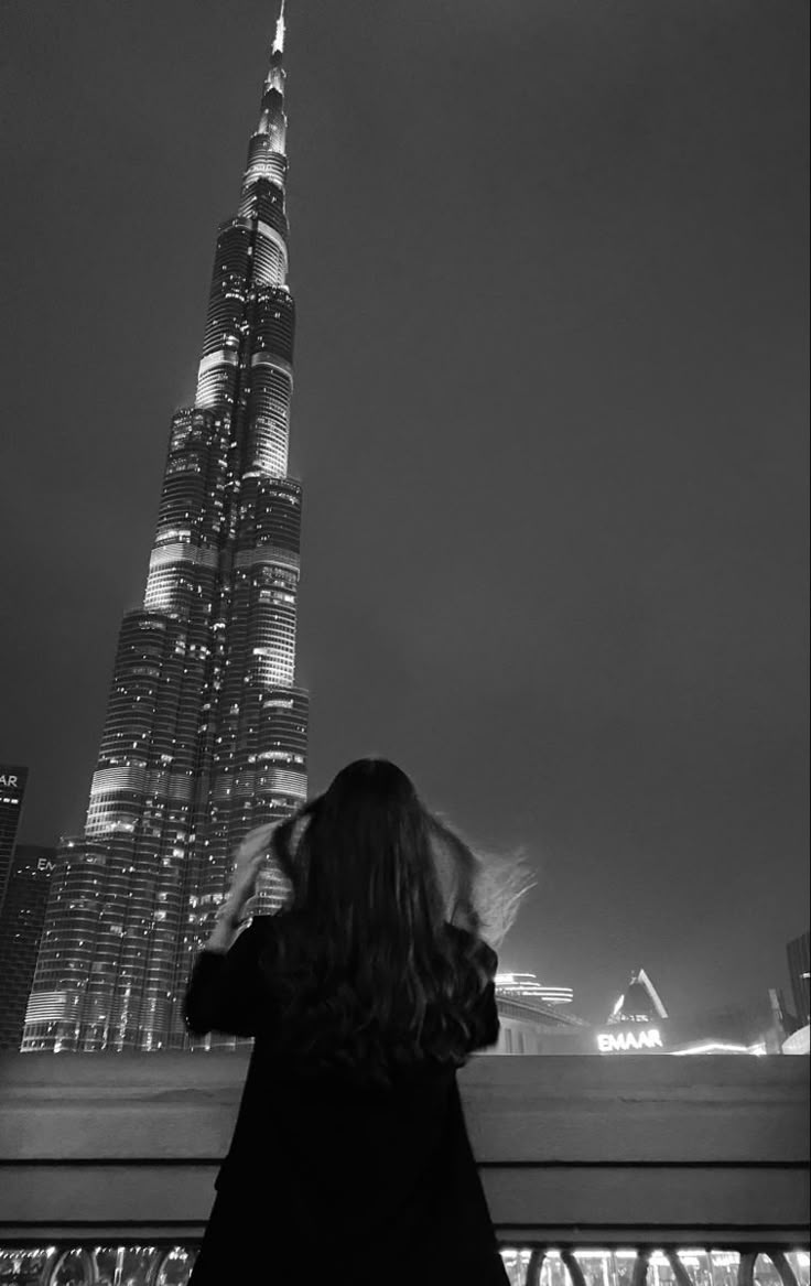 a woman standing in front of a tall building