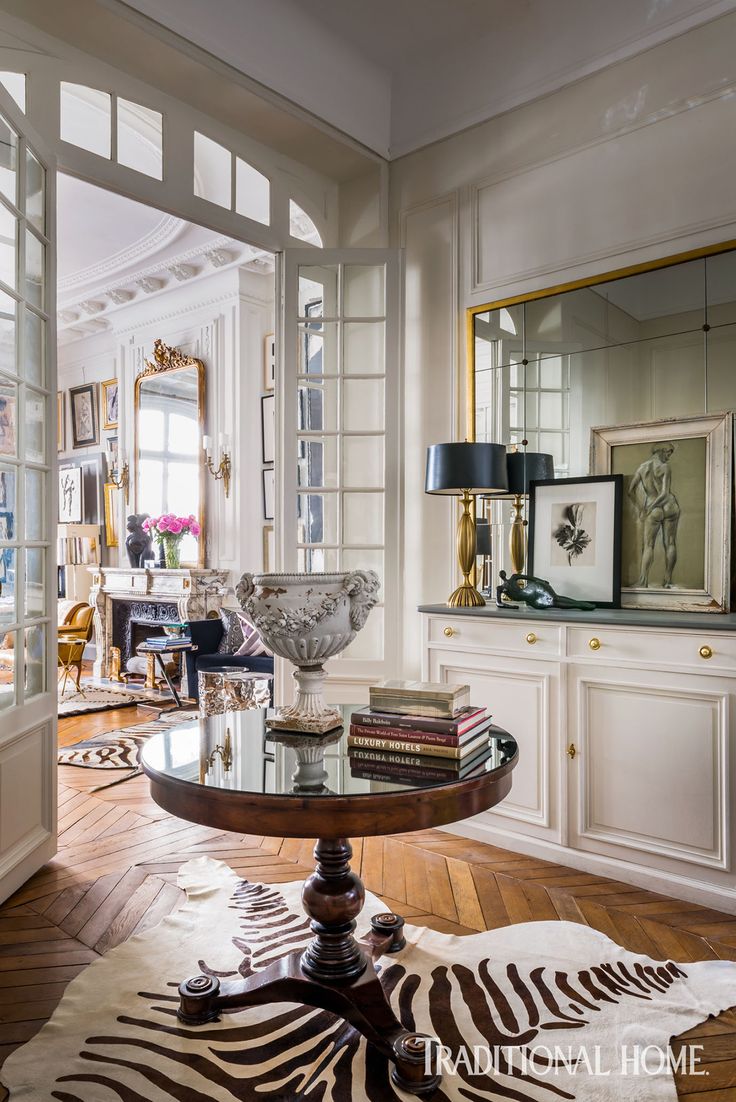 a living room filled with furniture and lots of mirrors on top of the wall next to a doorway