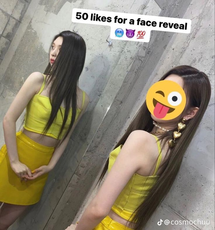 a woman with long hair wearing a yellow dress and emoticting smiley face mask