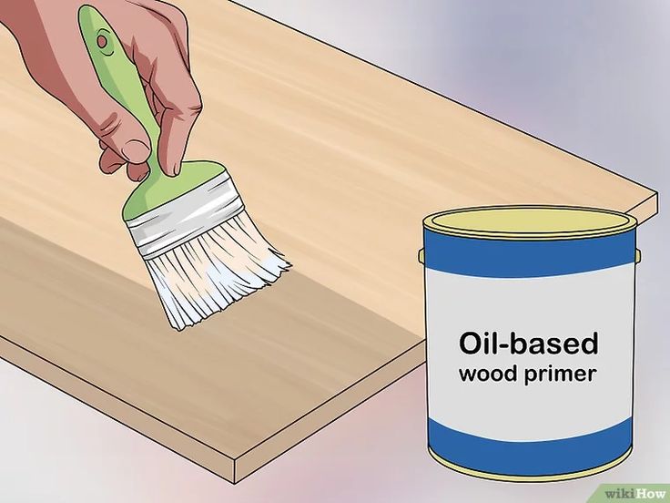 a person using a brush to paint a wooden table with an oil - based primer