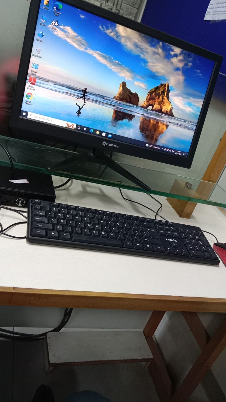 a computer monitor sitting on top of a wooden desk next to a keyboard and mouse