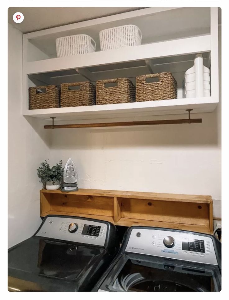 a washer and dryer in a small room with baskets on the top shelf