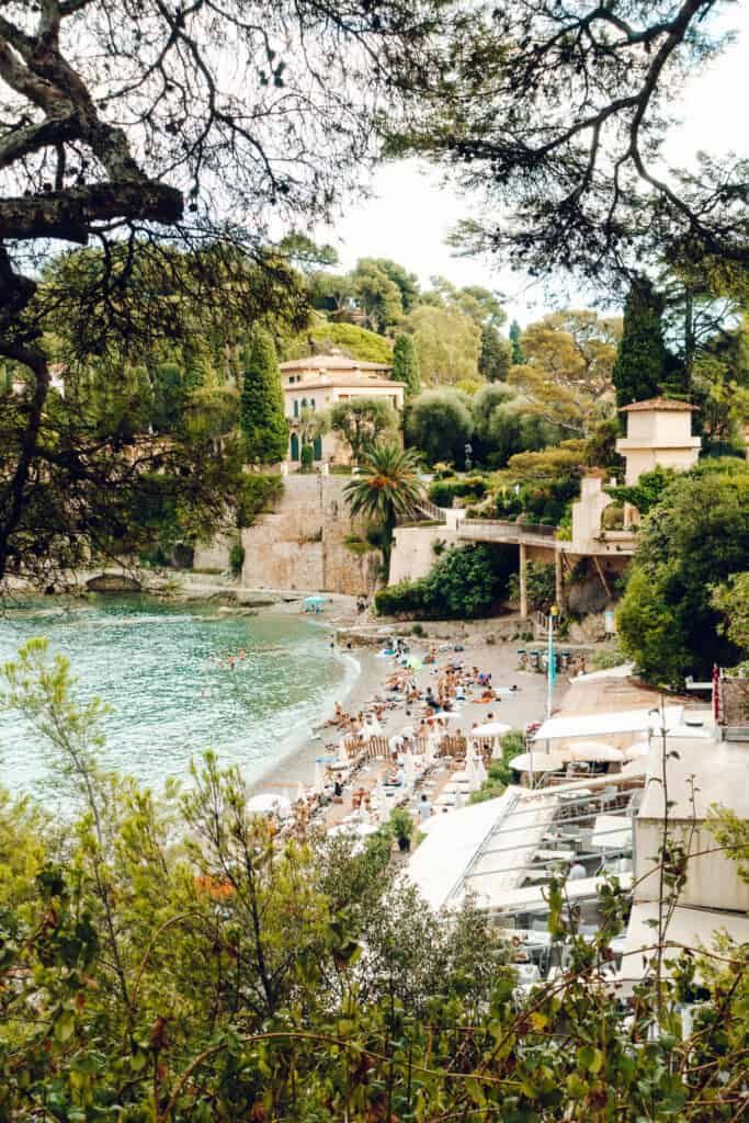 the beach is crowded with people on it's sides and trees in the foreground