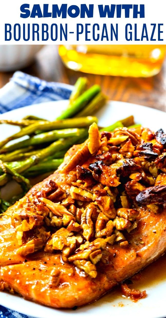 salmon with bourbon pecan glaze and asparagus on a white platter