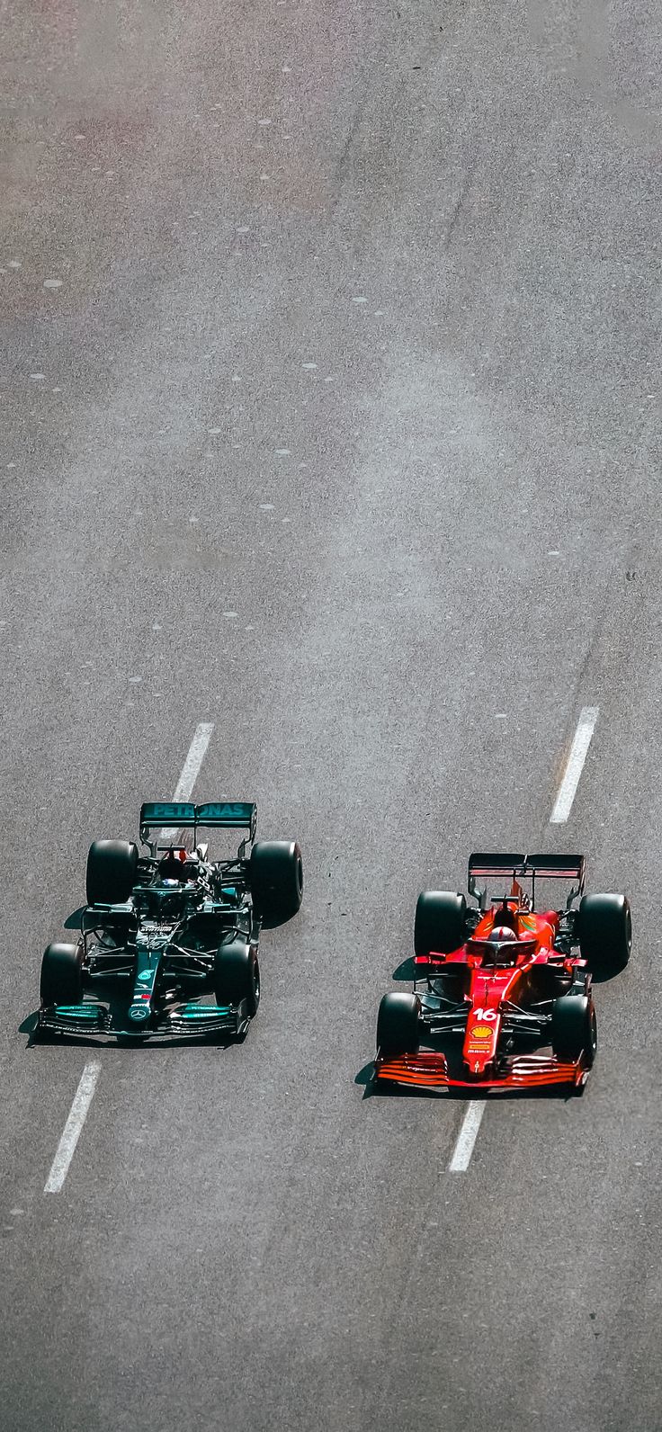 two racing cars are driving down the road