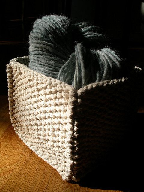 a basket with yarn in it sitting on the floor