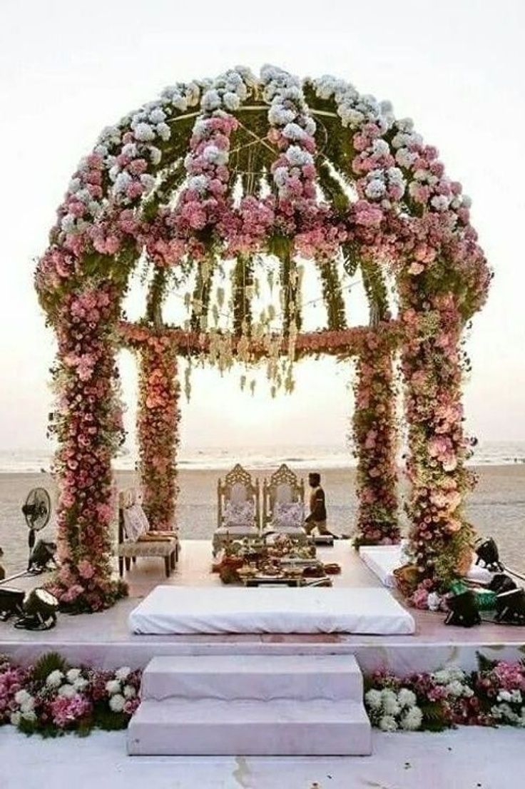 an outdoor ceremony set up with flowers and petals on the altar, overlooking the ocean