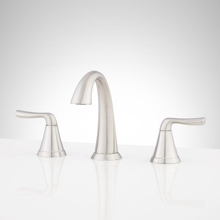 two chrome faucets on a white surface