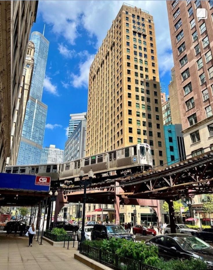 a train traveling through a city next to tall buildings