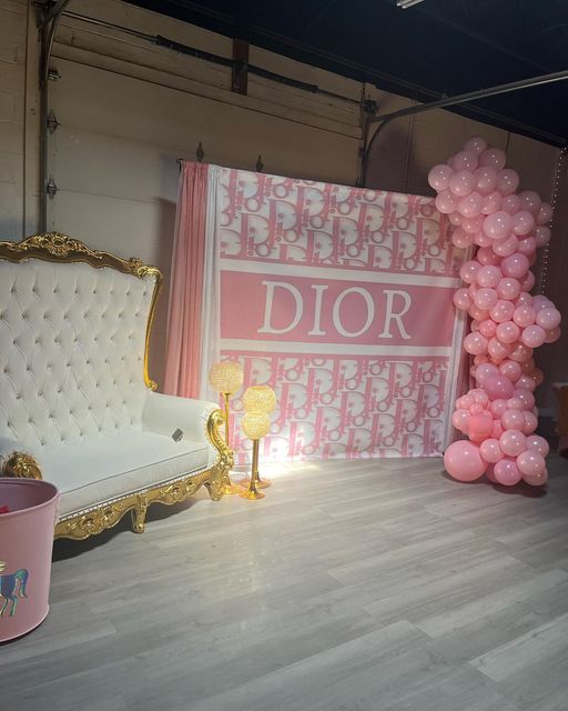 a room with pink balloons and a white couch