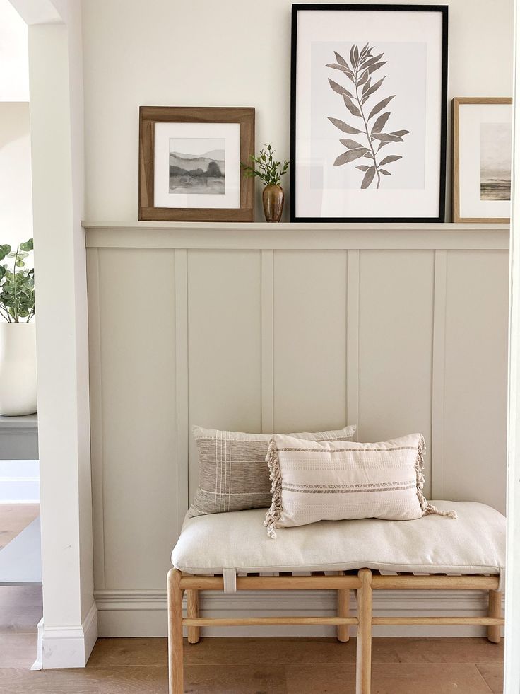 a bench with pillows and pictures on the wall