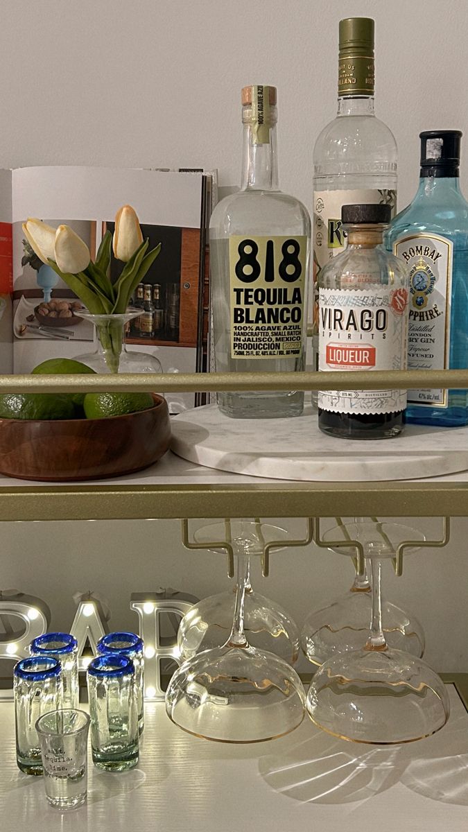 bottles and glasses are sitting on a shelf