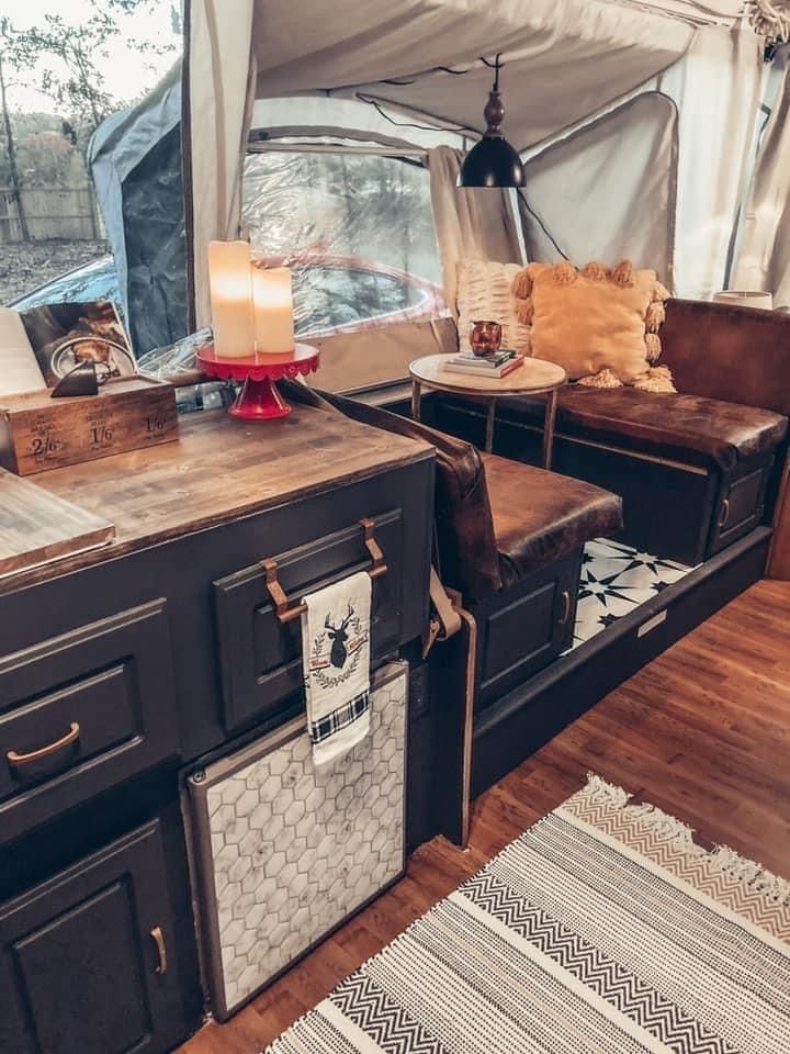 the inside of a camper with two couches and a table in front of it