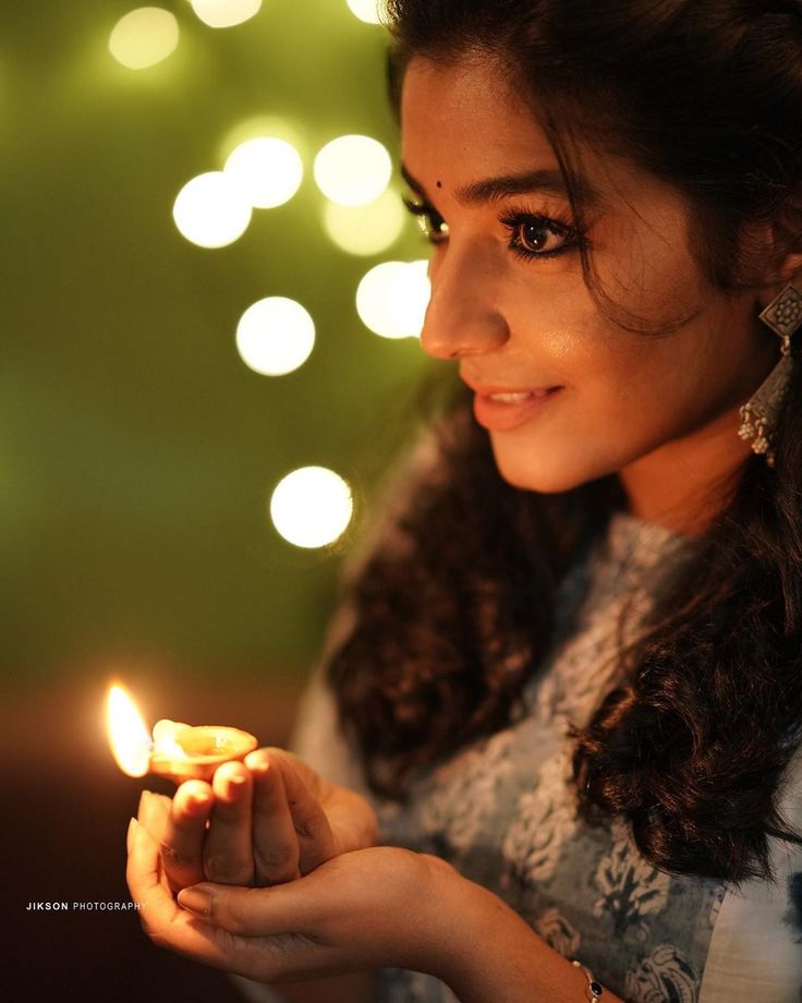 a woman holding a lit candle in her hand