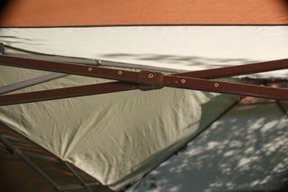 the inside of a tent with an open door and brown leather straps hanging from it