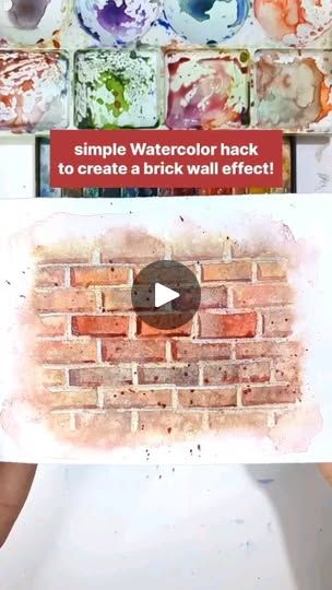 a person holding up a piece of paper with watercolor paint on it and the words simple watercolor hacks to create a brick wall effect