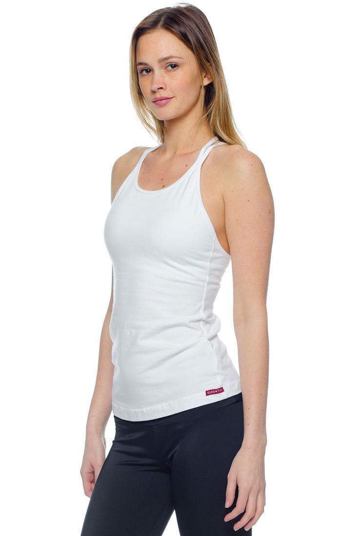 Elevate your basics with the Hard Tail Double Cross Tank. Featuring a White hue, with a high cut neckline, and a double cross design in back, this tank boasts chic style and freedom of movement. Made of a soft, flexible cotton/lycra blend fabric, with a built-in shelf bra, this tank offers comfortable style for in and out of the studio. Wear this tank for yoga, barre, gym sessions, or for everyday style.     Get the Deets:    High cut neckline, for full coverage.  Semi-fitted.  Pre-shr Cotton Tank Top With Built-in Bra For Gym, High Stretch Tops With Built-in Bra And Cross Back, Casual Cross Back Tank Top With Built-in Bra, Fitted Cross Back Tank Top With Built-in Bra, Stretch T-back Tank Top With Built-in Bra, Crisscross Straps Cross Back Tank Top, Stretch T-back Tops For Workout, White Stretch Halter Neck Tank Top, White T-back Top With Built-in Bra