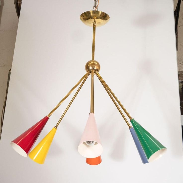 three multicolored lamps hanging from a ceiling fixture in a room with white walls