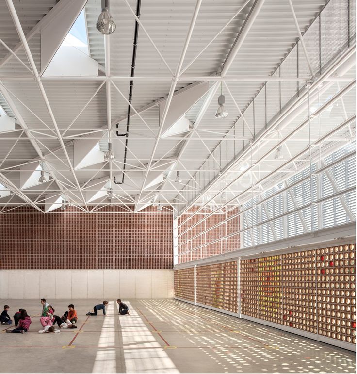 people are sitting on the floor in an empty building with lots of light coming through