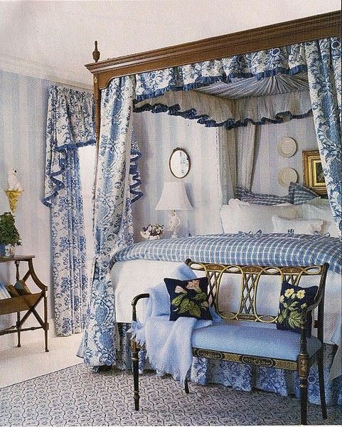 a canopy bed with blue and white curtains