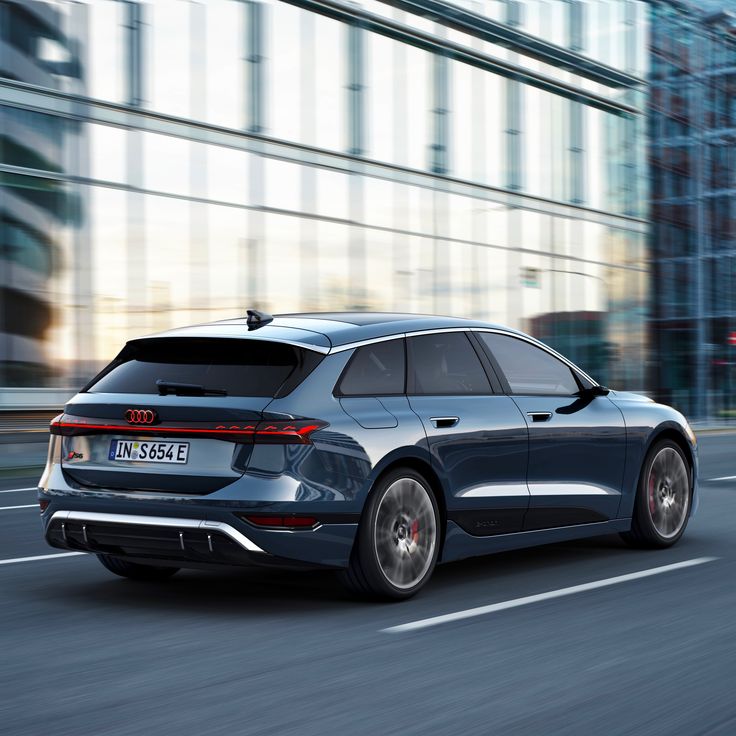 the rear end of a silver car driving down a city street