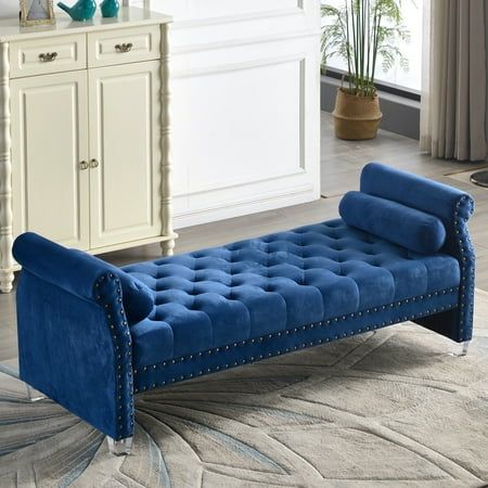 a blue bench sitting on top of a rug in front of a white dresser and window