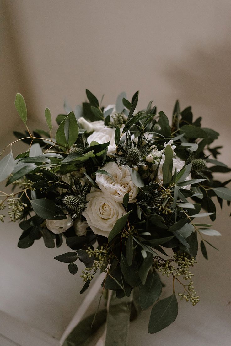 a bridal bouquet with white roses and greenery