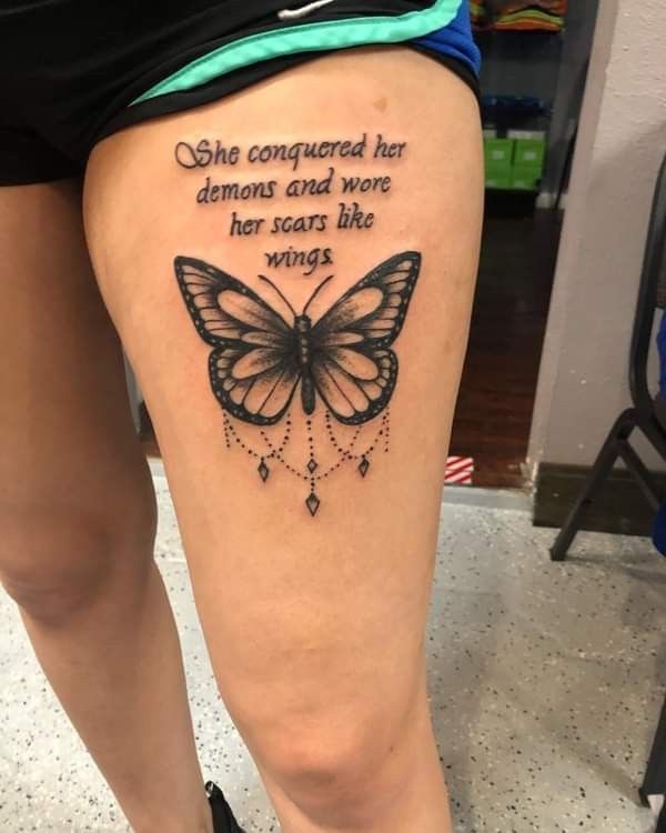 a woman's thigh with a butterfly tattoo on it and the words she congregated her demons and wore her scars like wings