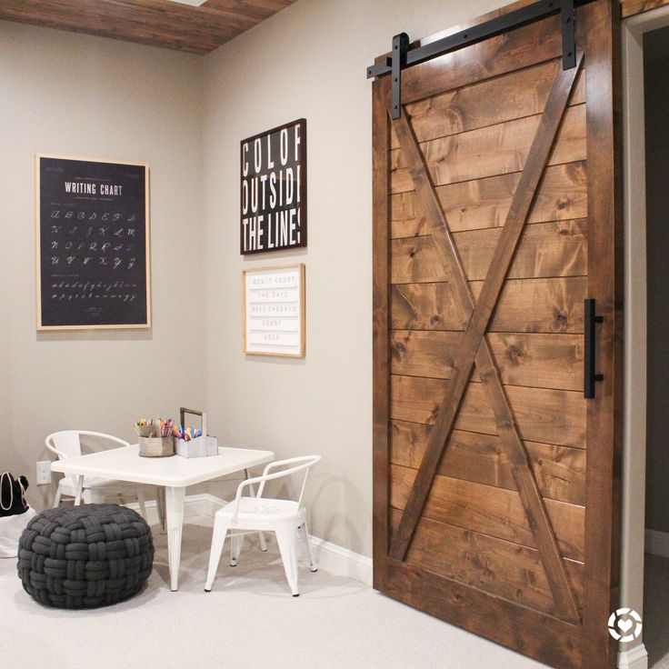 a room with a table, chair and sliding barn door