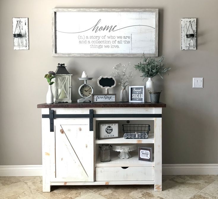 a white cabinet sitting next to a wall filled with pictures and decor on top of it