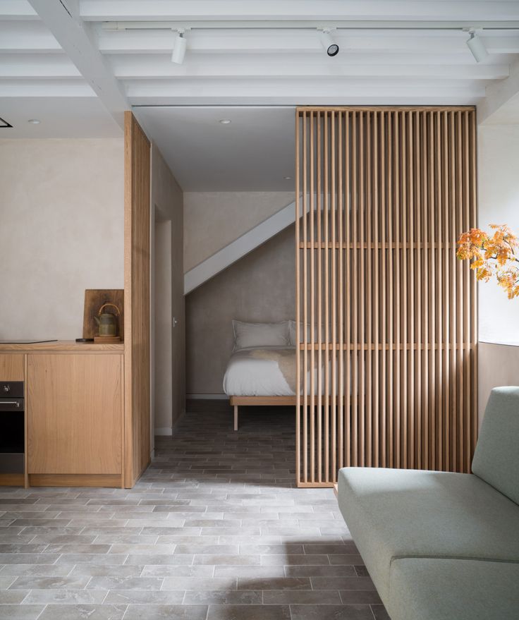 a bed sitting next to a wooden wall in a bedroom under a slanted ceiling