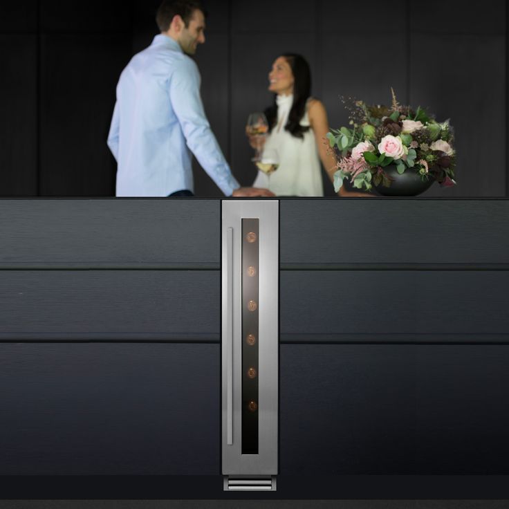 a man and woman standing next to each other in front of a counter with flowers on it