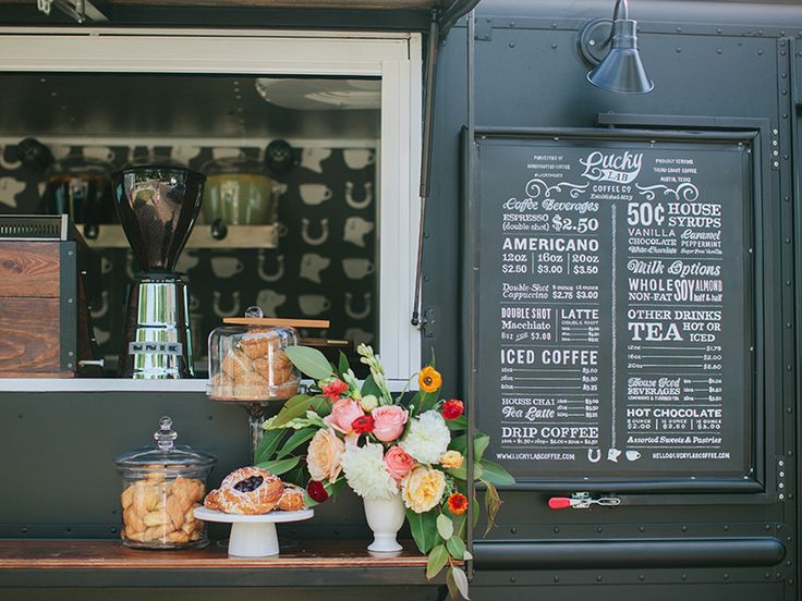 a table with pastries and flowers on it in front of a coffee shop window