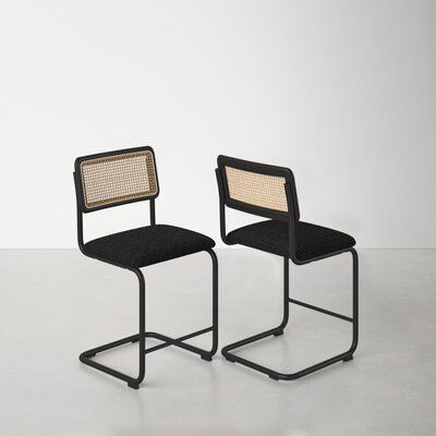 two black chairs with woven backrests on each side, one is facing the other