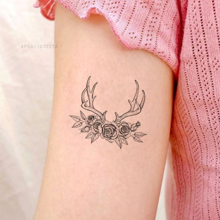 a woman's arm with a deer head and roses tattoo on the left side