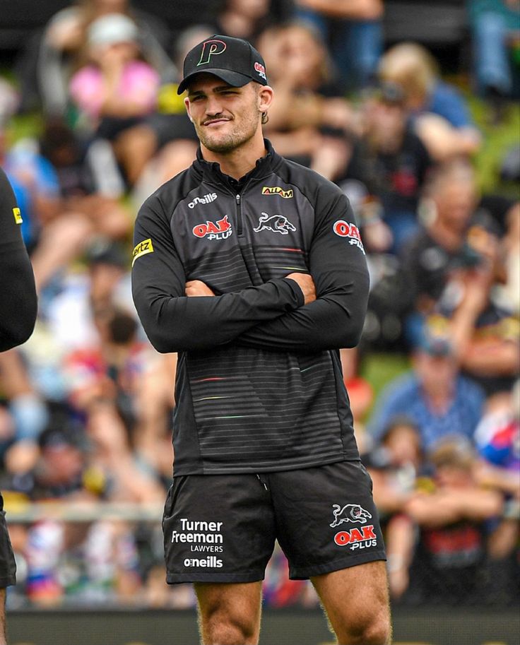 two men standing next to each other in front of a crowd with their arms crossed