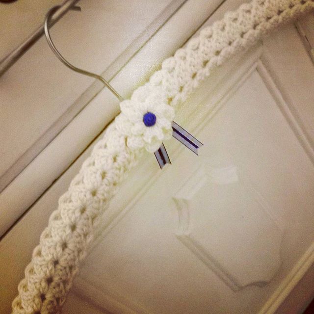 a white crocheted headband hanging from a hook