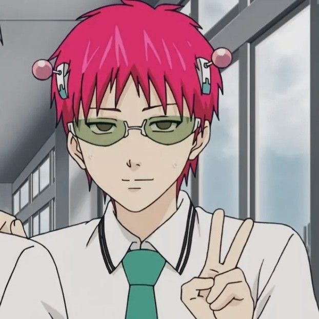 a man with pink hair and green glasses giving the peace sign