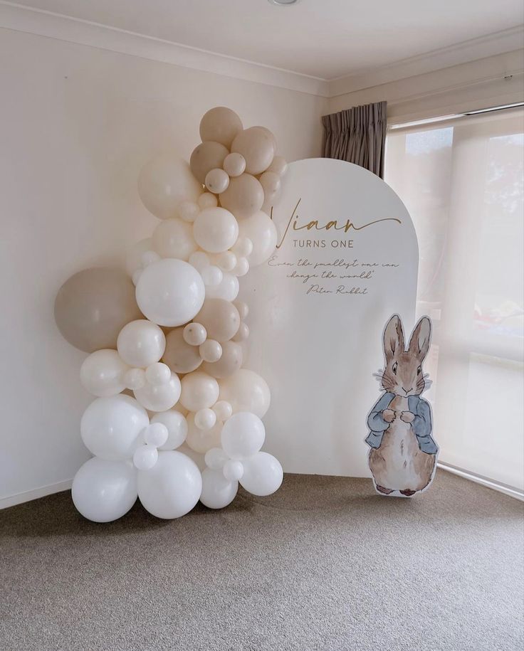 balloons are arranged in the shape of a rabbit and balloon arch for a baby's first birthday party