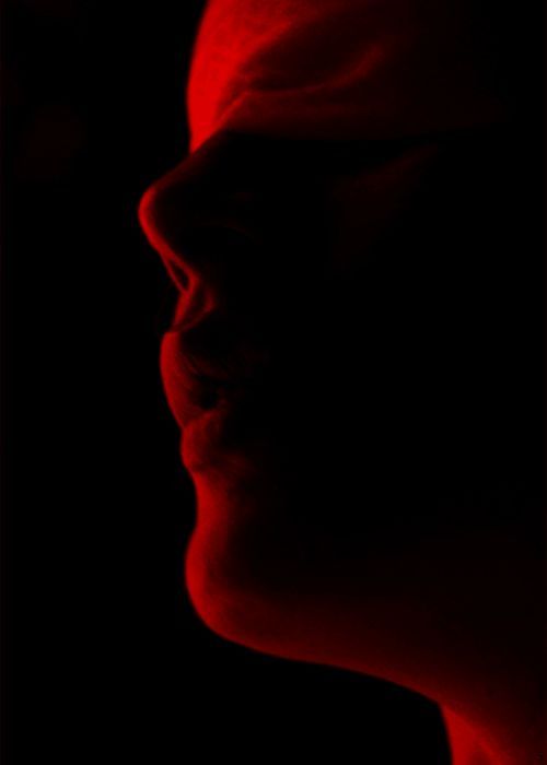 a woman's face is shown in red light