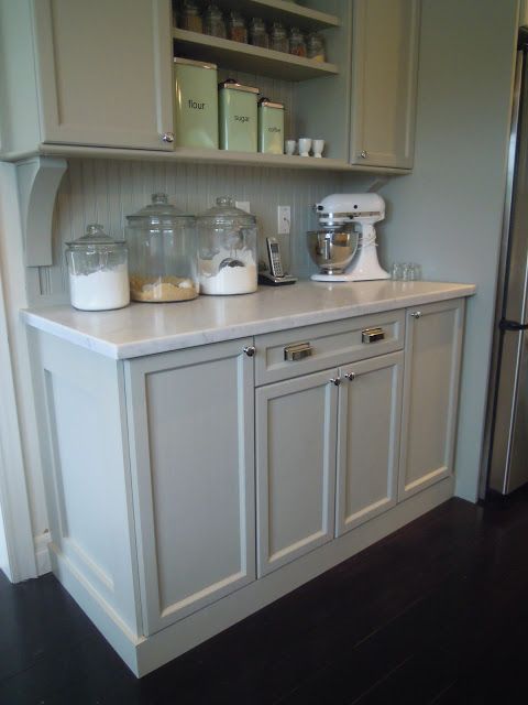 a kitchen with white cabinets and appliances in it