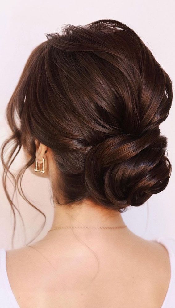 a woman with her hair in a low bun