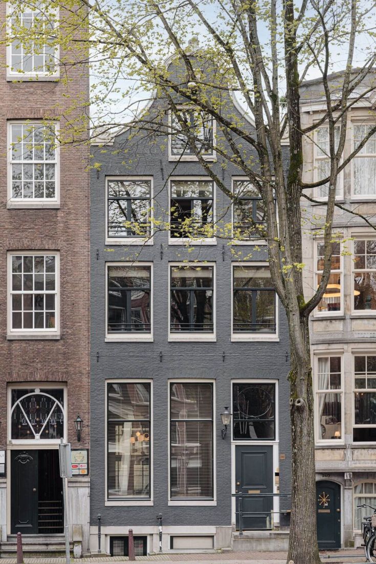 the building has many windows and doors on it's sides, along with two bicycles parked in front