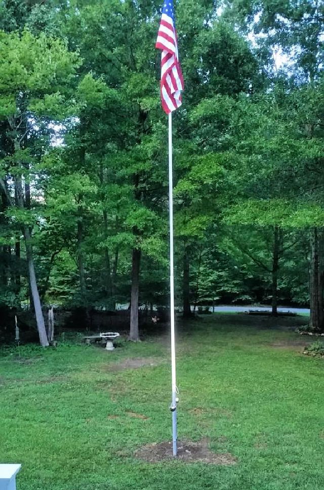 an american flag on a pole in the grass