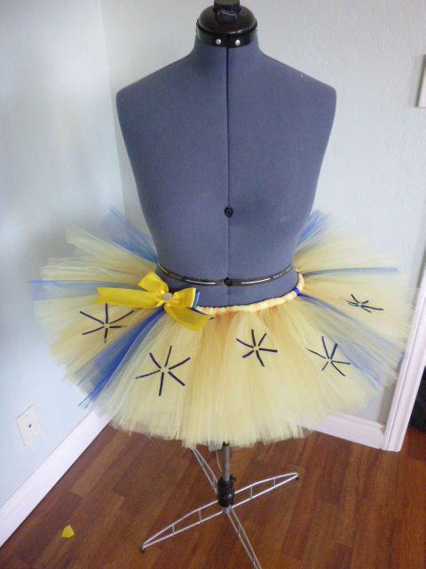 a mannequin wearing a yellow and blue tutu with stars on it's skirt