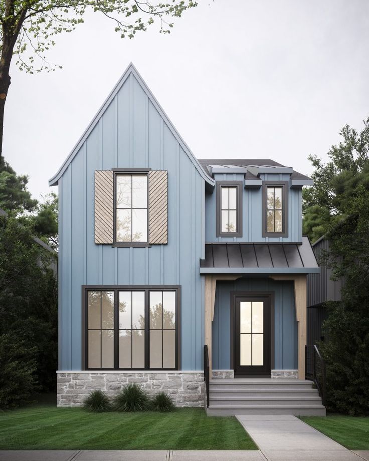 a blue house with two story windows and steps leading up to the front door is shown