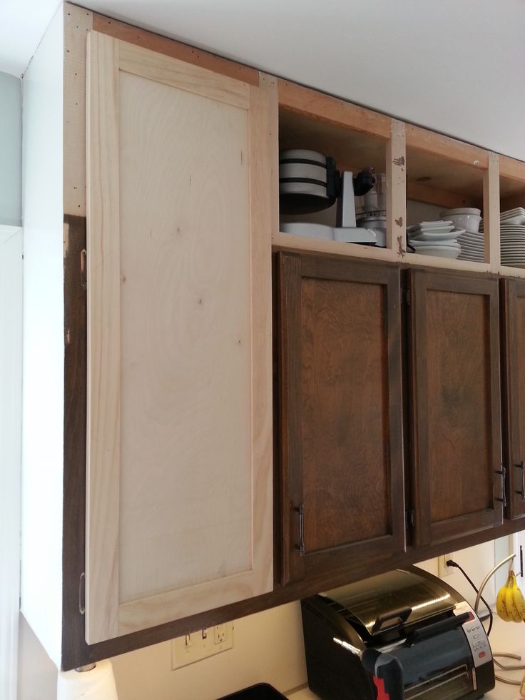 a kitchen with wooden cabinets and plates on the counter