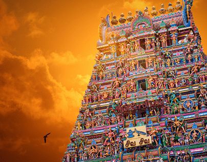 a very tall and colorful building with lots of statues on it's sides under a cloudy sky