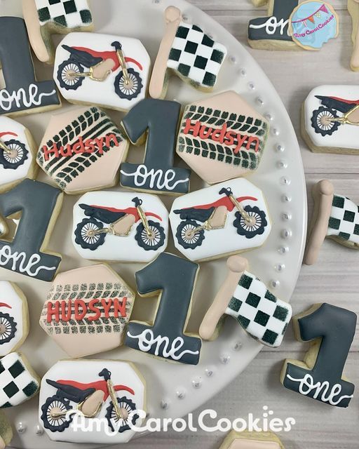 decorated cookies are arranged in the shape of racing bikes and numbers on a plate with words that spell out one